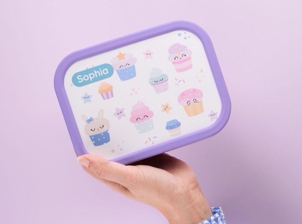 Personalized purple lunch box with cupcake designs and the name Sophia printed on the lid